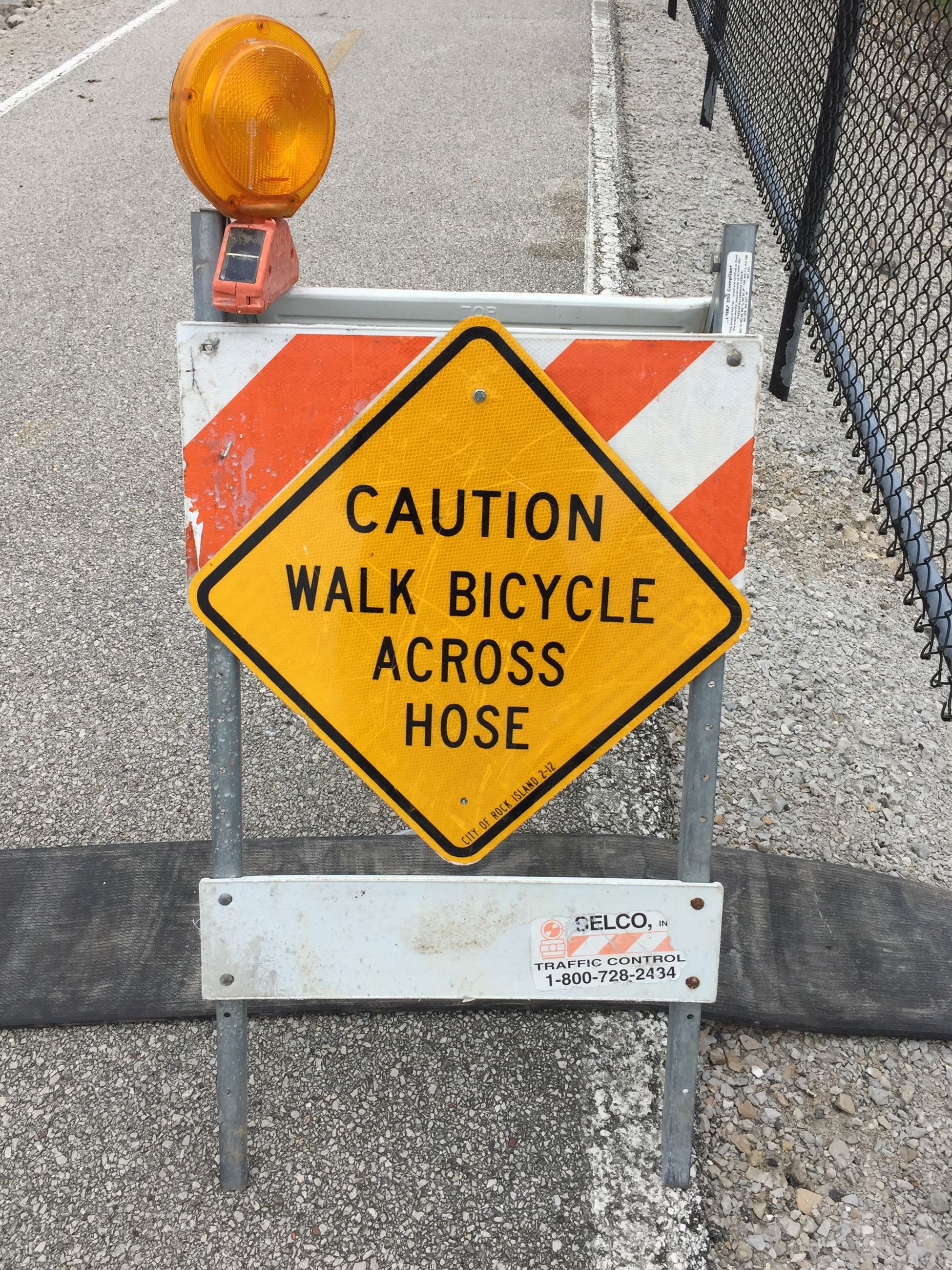 Caution Walk Bicycle Across Hose sign