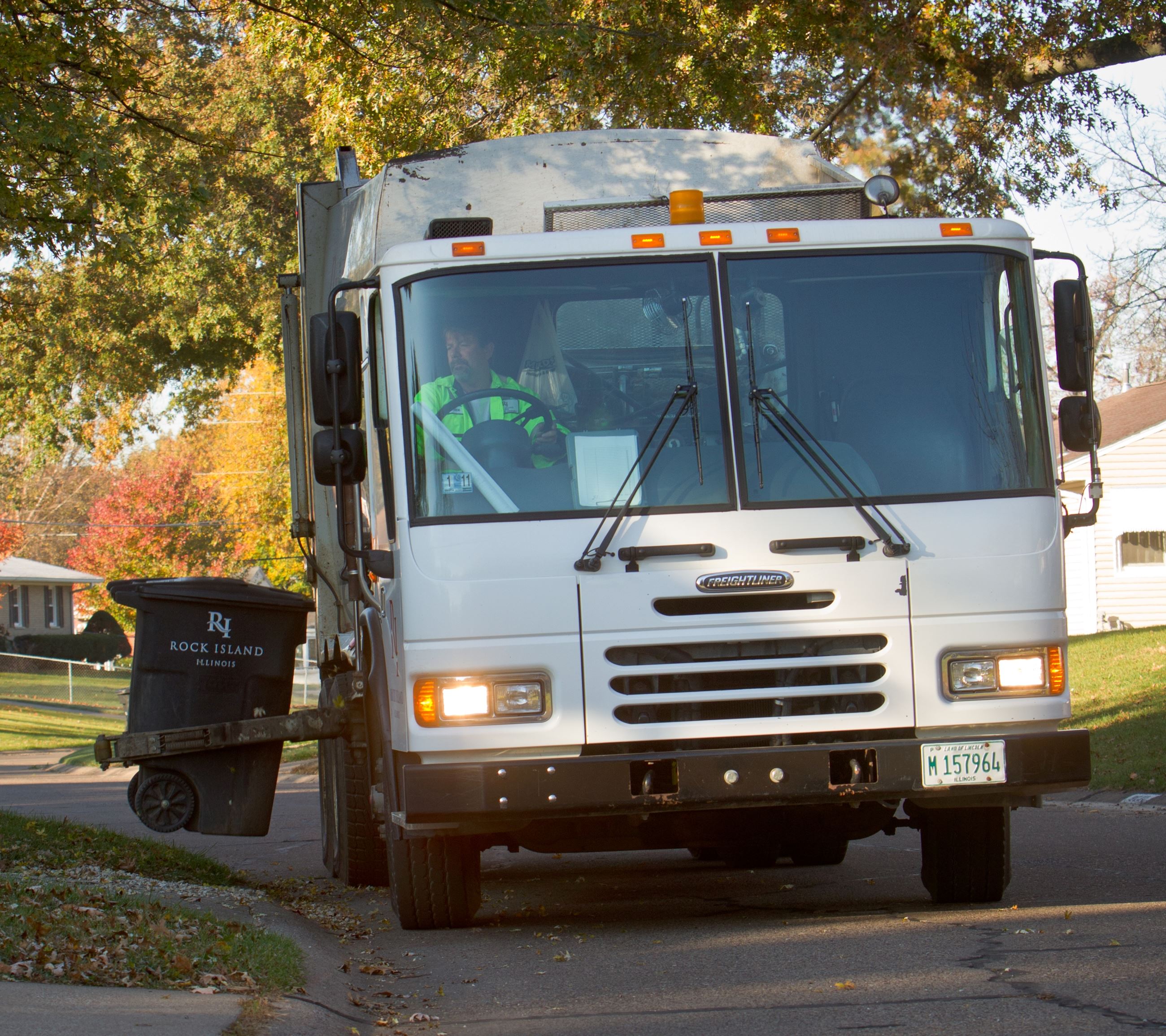Refuse truck and cart in neighborhood